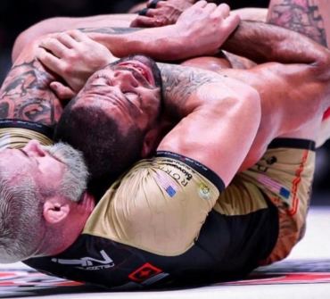 Dos competidores de grappling en el suelo durante una competición