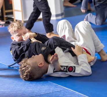 Dos niños entrenando BJJ en el tatami